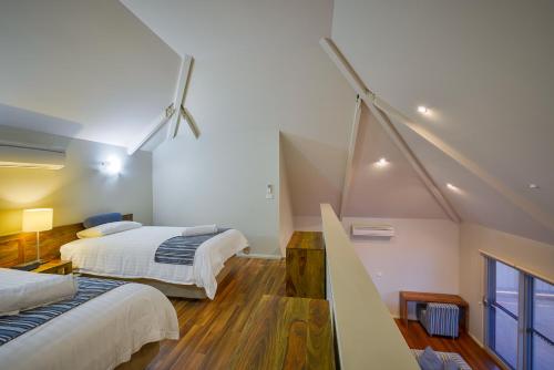 埃克斯茅斯埃克斯茅斯世外度假酒店的阁楼卧室设有两张床和楼梯。