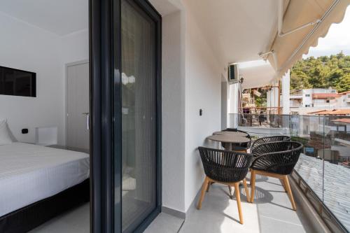 新马尔马拉斯SithoniaRS Luxury 1st Floor Apartment With SeaView的一间卧室设有一张床,阳台上设有一张桌子和椅子