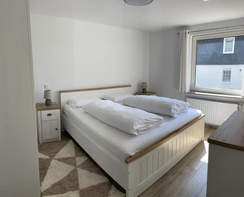 温特贝格Ferienwohnung Hildfeld KORS的卧室内的一张白色床,设有窗户