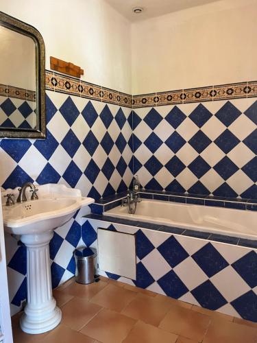 埃加利埃Chambre d'hôte au cœur de la Provence Eygalieres的蓝色和白色的浴室设有水槽和浴缸。