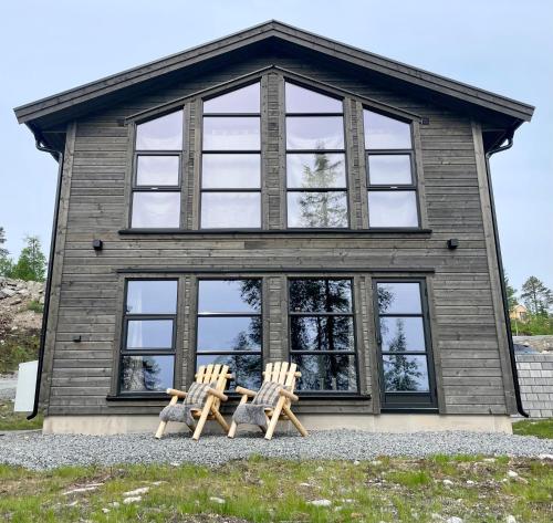 NoresundNorebu - Norefjell的两把椅子坐在房子前面