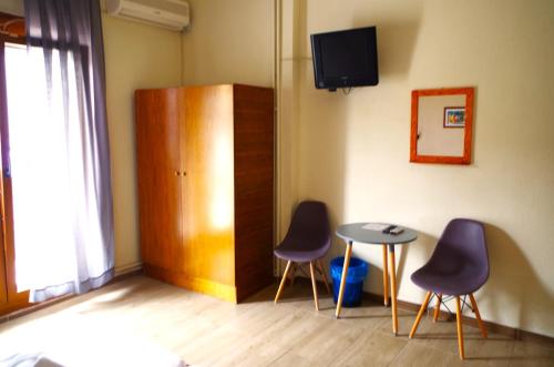 斯卡拉索提罗斯Sotiras Rooms的一间设有两把椅子、一张桌子和一台电视的房间