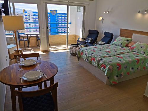 阿德耶Apartments Paraíso del Sur的卧室配有一张床和一张桌子及椅子