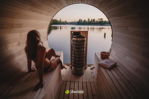 普日维兹Półwysep Zacisze - Tiny House Village的坐在船的顶端的女人