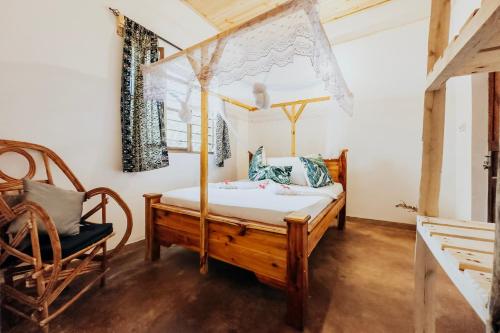 吉汶瓦The Kichwa House的一间卧室配有一张天蓬床和一把椅子