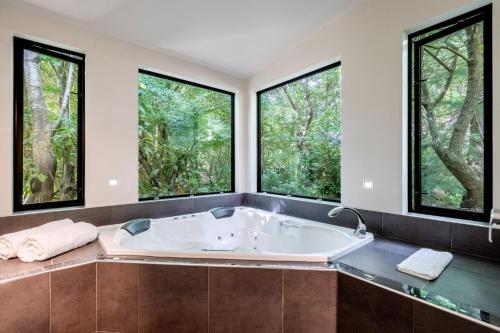 因弗卡吉尔Millton Park Estate的带浴缸的浴室,设有大窗户