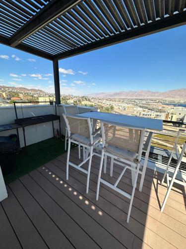 埃拉特Sea view penthouse Private rooftop jacuzzi的观景甲板上的桌椅