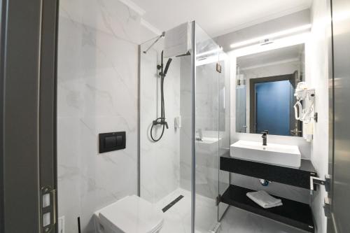 卡普奥罗拉HOTEL TOPAZ 4* CAP AURORA的带淋浴、卫生间和盥洗盆的浴室