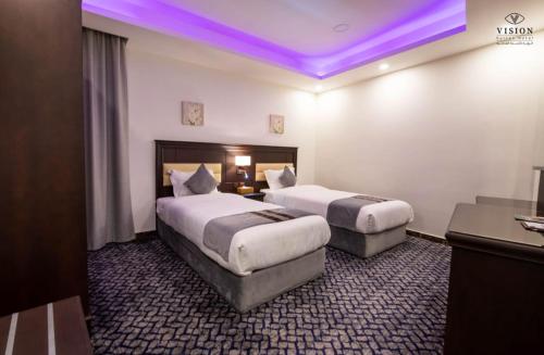 Al Buhrahفندق الرؤية محافظة الداير بني مالك的紫色照明的酒店客房内的两张床