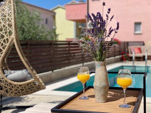 克尔克Charming Villa Ira with Pool的两杯橙汁和花瓶