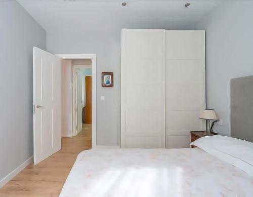 格乔COSY Apartment AREETA STATION las Arenas Getxo的卧室拥有白色的墙壁和一张大床
