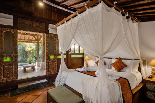 乌布Roshan Ubud Villa的一间卧室配有一张带天蓬的床