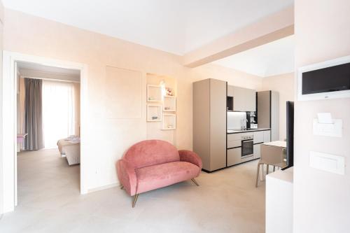 泰尔莫利La casa sul muraglione的一间带粉红色椅子的客厅和一间厨房