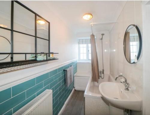 金斯坦顿Tubs Cottage的一间带水槽和镜子的浴室