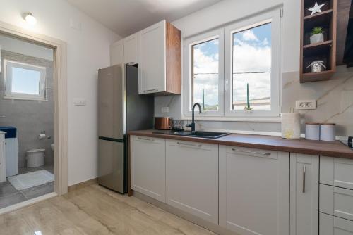 卡斯特尔·斯塔费力克Amazing sea view apartment- Romantica的厨房配有白色橱柜和水槽