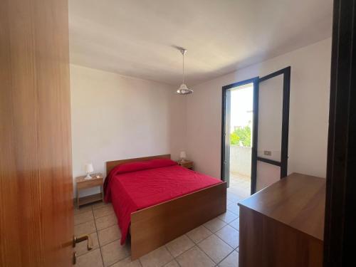 托里德欧索Mya Vacanze的一间卧室配有一张带红色毯子的床