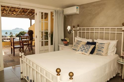 布希奥斯Pousada Baía Bonita的卧室设有白色床,享有海景