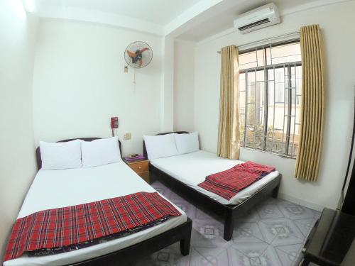 芽庄Yên Mỹ Hotel的带窗户的客房内的两张床