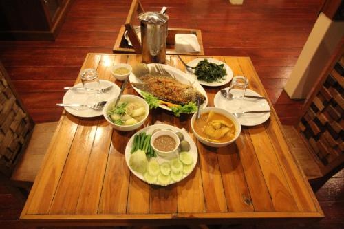 Ban Chieo Ko帕维里度假酒店的一张木桌,上面放着食物盘