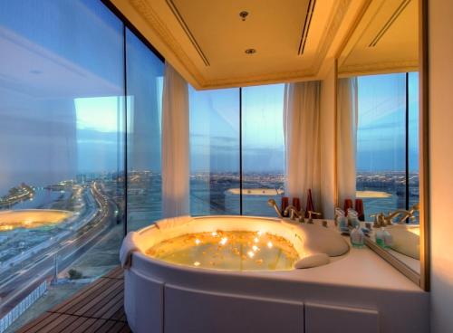 吉达吉达瑰丽酒店的一间带两个浴缸和大窗户的浴室