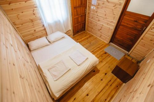 奥林波斯Kadir's Family House的铺有木地板的客房内的一张小床