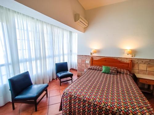 坎布里尔斯Hotel Can Solé的酒店客房,配有一张床和两把椅子