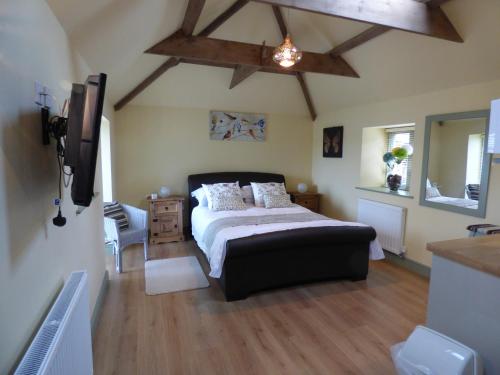 林肯Cosy Studio Cottage的一间卧室设有一张大床和木制天花板