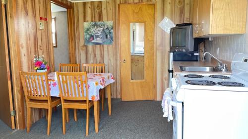 SurreyRachel's Motel and Cottages的厨房配有桌椅和炉灶。