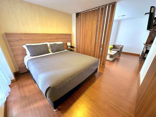 波哥大Cómodo Apartaestudio en super ubicación的一间卧室设有一张大床,铺有木地板