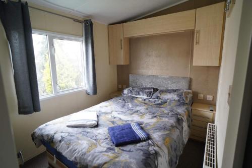 亨斯坦顿Manor at Manor Park Hunstanton WiFi pets go free的一间卧室配有一张带蓝色床单的床和一扇窗户。