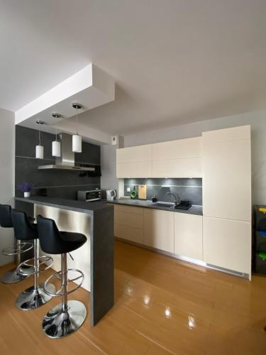 格涅维诺Apartament Nova Gniewino的厨房配有白色橱柜和黑色台面
