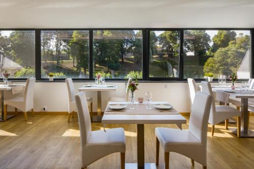 巴伦西亚凯悦酒店的餐厅设有白色的桌椅和窗户。