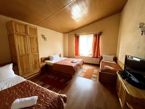 YundolaVila Katerina的酒店客房设有两张床和窗户。