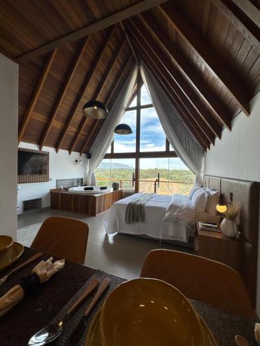 新文达移民镇Chalés Laguna Alto Viçosa的一间卧室设有一张床和一个大窗户
