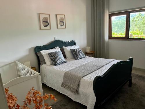 马尔科-德卡纳维泽斯Casa Mira Tâmega的卧室配有带枕头的床铺和窗户。
