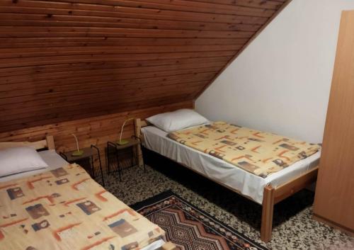 毛焦尔海尔泰伦德Mecsek Virágai Lak的木墙客房的两张床