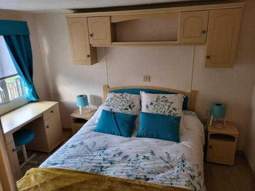 Le NeufbourgMobil Home à la ferme的小卧室配有带蓝色枕头的床