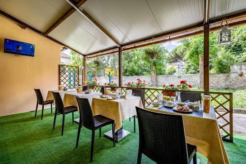 比萨密涅瓦酒店的餐厅设有桌椅和大窗户。
