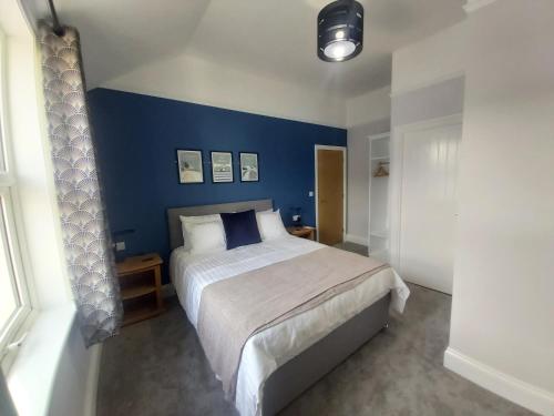 托特兰Bay House的一间卧室设有一张蓝色墙壁的大床