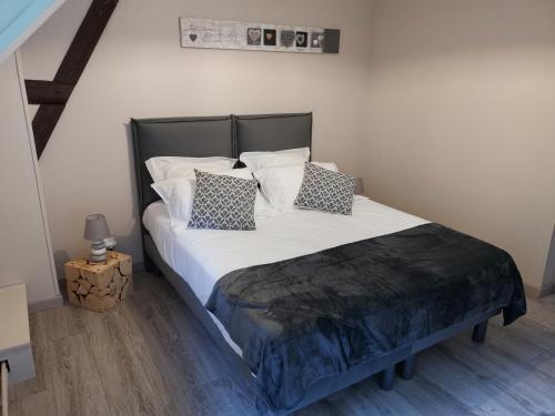 Sainte-Marie-au-BoscLe manège Gite Le Tilleul的卧室配有一张带白色床单和枕头的大床。