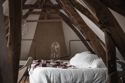 蒙特勒伊格雷诺伊勒尔酒店的阁楼上配有一张带白色床单和枕头的床。