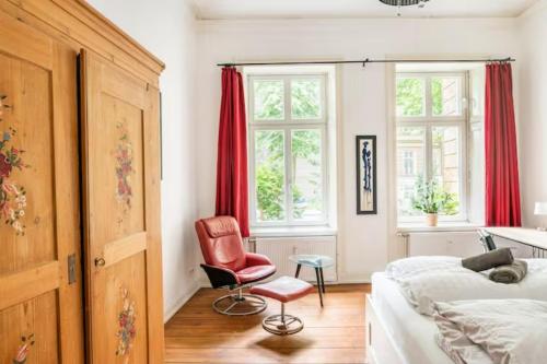 汉堡Großzügige Altbauwohnung in Bestlage的一间卧室配有一张床和一张红色椅子