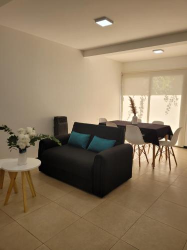 瓜伊马延Lujoso apartamento cómodo y luminoso con seguridad 24 hs y estacionamiento的客厅配有黑色沙发和桌子