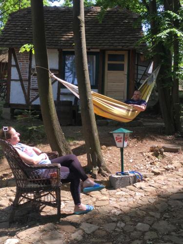 Etno selo Krugerdorf的两人坐在院子里的吊床上