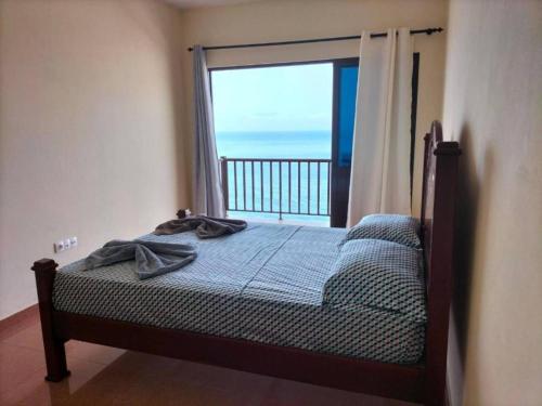 圣菲利佩Casa Joãozinho De Lora的一间卧室设有一张床,享有海景