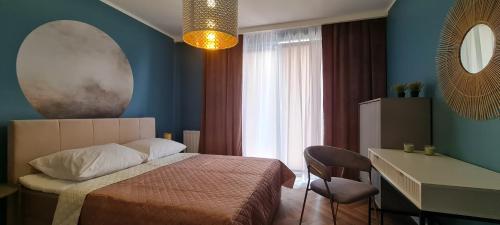 普沃茨克Mazovia Gold Apartament 101的一间卧室配有一张床、一张书桌和一个窗户。