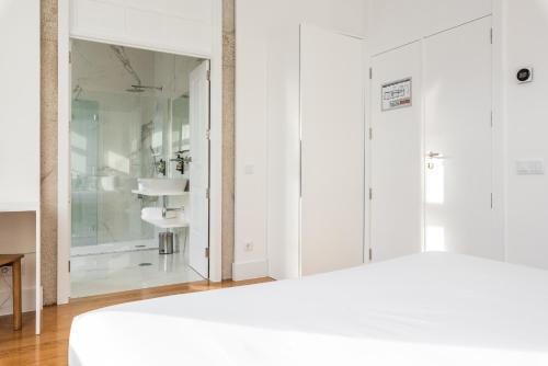 维亚纳堡Avenida Viana Boutique Suites的卧室配有白色橱柜和玻璃淋浴间。