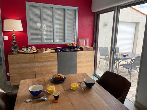 佩里尼Les Pertuis Rochelais的一间设有木桌和红色墙壁的用餐室