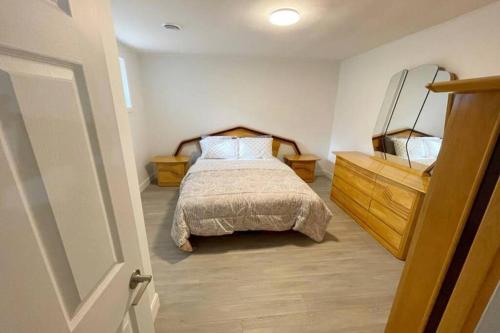 隆格伊Stylish and luxurious apartment basement unit的一间卧室配有一张床和一个木制梳妆台