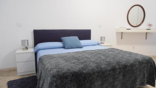 拉加里塔La Marea Azul的一间卧室配有一张带蓝色枕头和镜子的床